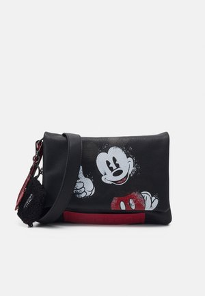 Black leather crossbody bag with a faded white and red Mickey Mouse graphic and a black pom-pom keychain attached to the strap.