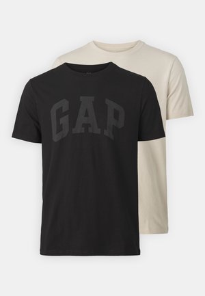 Kaks T-särki: üks must tumehall „GAP“ logoga, teine kreemjas. Mõlemad on lühikeste varrukatega ja klassikalise ümaralusega.