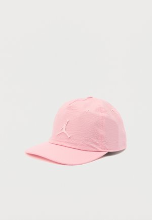 Casquette de baseball rose pâle texturée avec une visière incurvée et un logo Jumpman en relief brodé sur le devant.