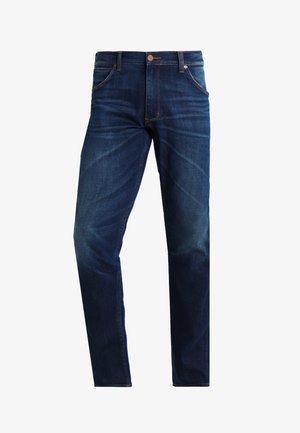 Donkerblauwe denim jeans met een klassieke rechtstreekse pijp, vijf pockets, subtiele slijtage en oranje stiksels. Koperen knoopsluiting.