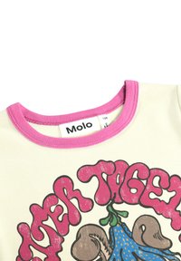 Kremna majica s kratkimi rokavi z rožnatim rebrastim ovratnikom, na kateri je barvita grafika tigra in gobe. Vidna blagovna oznaka.