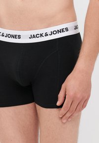 Schwarze Baumwollboxershorts mit einem weißen Bündchen, auf dem "JACK & JONES" in fetten schwarzen Buchstaben steht. Sie verfügen über ein nahtloses Design und eine figurbetonte Passform.