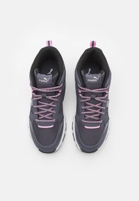 Baskets de sport grises avec des accents roses, des lacets à motifs, un col rembourré et des semelles blanches, arborant un logo sur la languette.