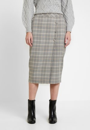 Geverifieerde midi-jurk in beige, zwart en crème; heeft een aansluitende pasvorm, zijknoppen en een gladde textuur. Gdraagd met zwarte enkellaarsjes.