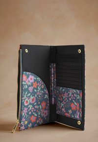 Květinová peněženka se zipem v tmavě modré barvě, s různobarevnými květinami, černým interiérem, více sloty na karty a kapsou na mince. Zlaté kovové detaily.