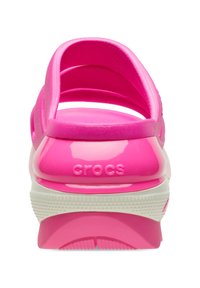 Różowe gumowe klapki o błyszczącym wykończeniu, z białą podeszwą środkową i otwartym zapiętkiem. Logo marki jest widoczne z tyłu.