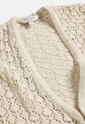 Cremefarbener, offen gestrickter Cardigan mit gewelltem Rand, der ein filigranes florales Spitzenmuster aufweist, mit einem Größenetikett 38/40 von Cellbes aus Schweden.