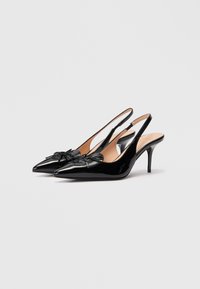 Melnas patentētas slingback papēžu kurpes ar norādītām purngaliem un dekoratīvu lentu frontē. Šaurie stiletto papēži piešķir elegantu akcentu.