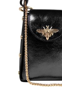 Zwarte gepatineerde leren handtas met een gouden bij-embleem op de klep, versierd met een kettingschouderband en gouden hardware accenten.