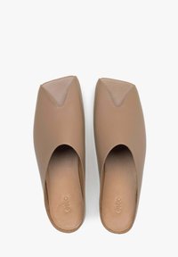 Brown leather mules with a pointed toe design, open sides, and a smooth texture. The interior features a subtle embossed brand logo.
