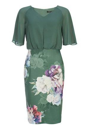 Groene blouse met korte, vloeiende mouwen en een diepe V-hals, gecombineerd met een getailleerde kokerrok met bloemenprint in lichte en donkere tinten.