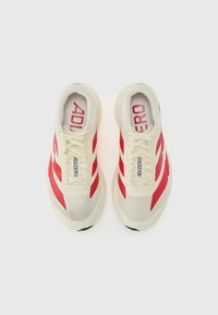 Hvite idrettssko med røde striper og "ADIZERO" merkevare på tungen og sidene; teksturert mesh-stoff, lett design og gummisåle.