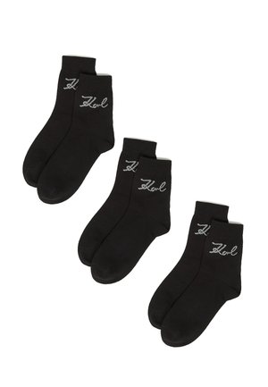 Schwarze Knöchelsocken aus Baumwollmischung, ausgestattet mit einem silbernen gestickten Logo an der Seite, einem standardmäßigen gerippten Bündchen und einer glatten Textur.