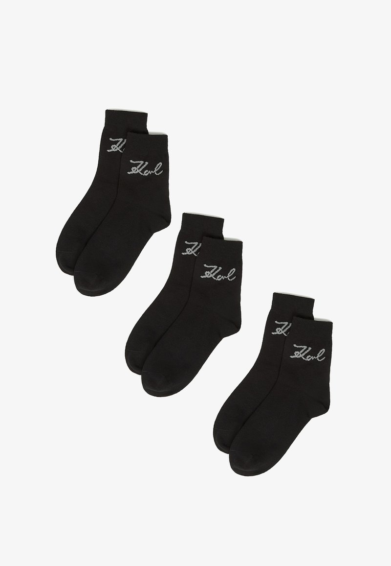 Chaussettes noires mi-mollet en mélange de coton, avec un logo brodé argenté sur le côté, disposant d'un bord-côte standard et d'une texture lisse.