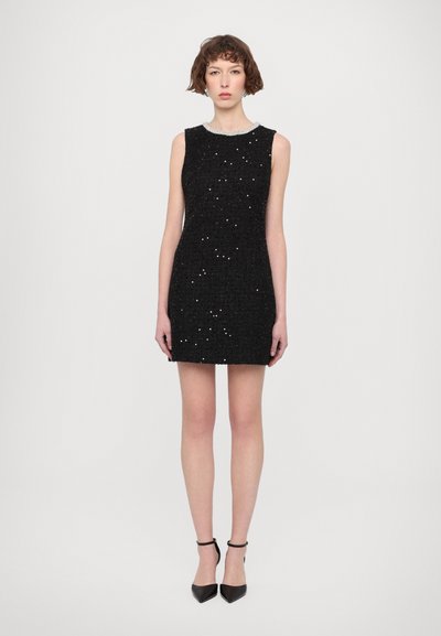 Abito nero senza maniche realizzato in tessuto testurizzato, decorato con paillettes argento. Presenta un colletto rotondo e una silhouette aderente.