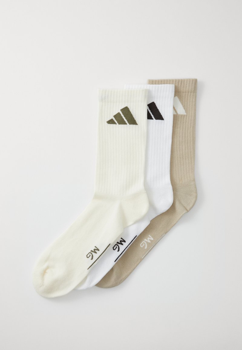 Tres pares de calcetines de tripulación: uno en blanco roto con logo verde, uno blanco con logo negro y uno beige con logo crema; textura acanalada.
