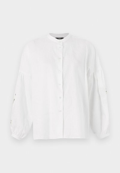 Hvit lin-skjorte med mandarin-krage, knappestekning foran og voluminøse, rynkede ermer med broderte detaljer på mansjettene.
