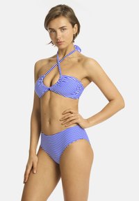 Bikini a righe blu e bianche con top incrociato e design a chiave, e slip a vita alta, tessuto morbido.