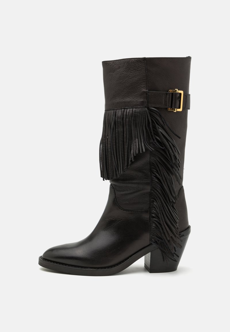 Black leather knee-high boot with a fringed accent, gold buckle detail, pointed toe, and a block heel. Smooth texture with matte finish.