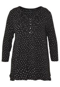 Tunic nera con motivo a pois bianchi, scollatura rotonda, patta con bottoni e maniche lunghe. Tessuto leggero con vestibilità ampia e dettagli plissettati.