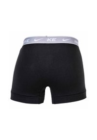 Schwarze Boxershorts mit einem grauen elastischen Bund, auf dem das Nike-Logo zu sehen ist. Hergestellt aus einem glatten, dehnbaren Stoff mit enganliegendem Sitz.