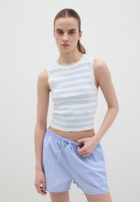 Gestreiftes Tanktop in Weiß und Hellblau mit figurbetontem Schnitt. Kombiniert mit hellblauen, gestreiften Shorts mit Kordelzug. Glatte Textur.