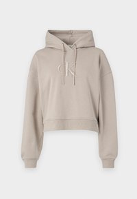 Sudadera corta de color beige hecha de una tela suave; cuenta con una capucha ajustable y el logotipo bordado 'CK' en el pecho. Puños y dobladillo acanalados.