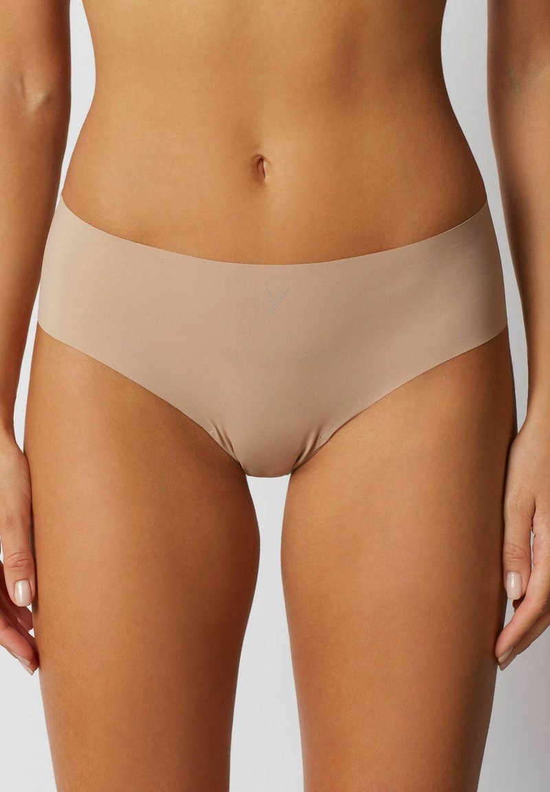 Mutandine hipster nude senza cuciture con una texture morbida e liscia. Presentano un design minimalista e una leggera lucentezza sul materiale.