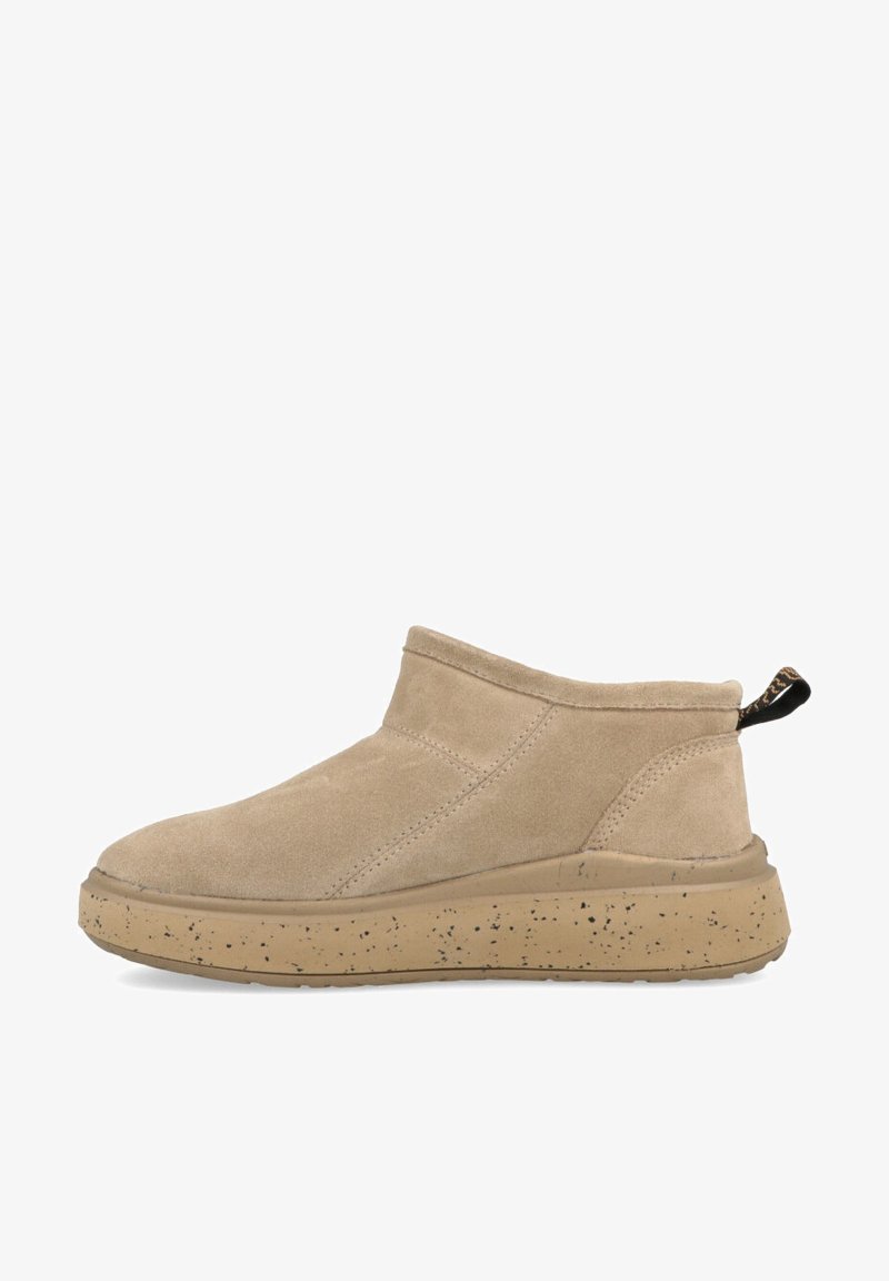 Stivali alla caviglia in suede beige con punta tonda, lati elasticizzati e suola in gomma beige maculata. Include un pratico lembo sul retro per facilitare l'indossamento.