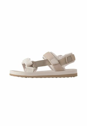 Helle beige Sandalen mit verstellbaren Riemen, strukturiertem Stoff und konturierten Sohlen. Sie verfügen über ein flaches Design und minimalistische Akzente.