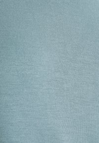 Ljusblått texturerat tyg med fina vertikala ribbor, som ger ett mjukt och jämnt utseende. Perfekt för kläder eller möbelklädsel.