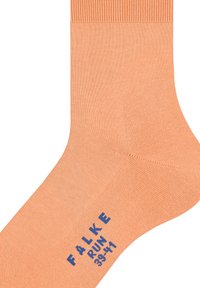 Απαλό πορτοκαλί κάλτσα από μαλακό υλικό, με ριχτό τελείωμα. Οι λέξεις "FALKE" και "RUN" σε μπλε χρώμα είναι τυπωμένες κοντά στην περιοχή του δακτύλου.