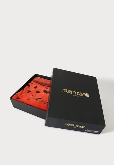 Μαύρο κουτί Roberto Cavalli Home μερικώς ανοιχτό που δείχνει διπλωμένο κόκκινο ύφασμα με μαύρα στίγματα μέσα.
