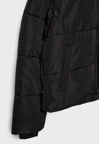 Manche et côté d'une veste matelassée noire avec poche zippée verticale sur tissu lisse.