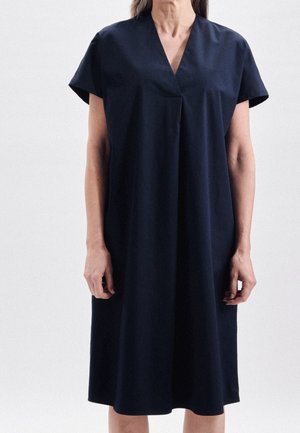 Robe bleu marine en tissu à finition douce, avec un décolleté en V, des manches courtes et une silhouette décontractée, arrivant aux genoux.