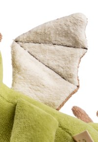 Green plush toy with a soft texture, featuring a beige wing detail with triangular sections and a brown accent at the edge.