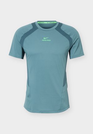 Ανοιχτό μπλε αθλητική κοντομάνικη μπλούζα Nike Pro με σκούρα πλέγματα στους ώμους και στα πλαϊνά, και φωσφορίζον πράσινο λογότυπο στο στήθος και το γιακά.