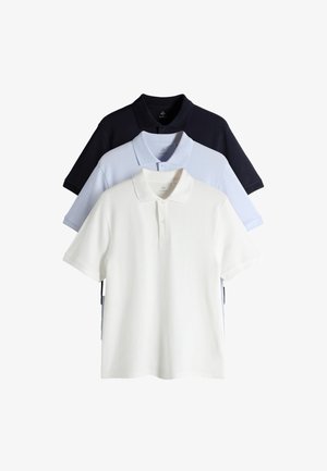 Tre polo a maniche corte piegate in bianco, azzurro chiaro e nero, impilate con il bianco davanti su sfondo bianco.