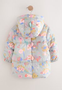 Doudoune à capuche pour tout-petit avec des motifs de dinosaures et de fleurs pastel en rose, bleu, jaune et gris, suspendue à un cintre en bois.