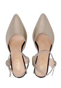 Beige spidse hæle med satinfinish, ankelrem og sort detalje ved sålen. Indersiden har en tekstureret indlægssål og gylden branding.