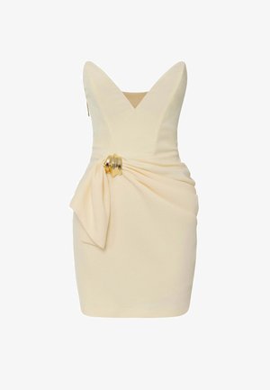 Abito corto in crema con scollatura a V profonda, dettagli drappeggiati in vita e un accentuazione dorata. Tessuto liscio e design aderente.