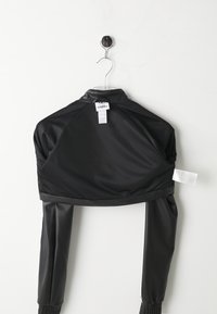 Svart cropped jakke med lange ermer. Laget av glatt materiale, med ståkrage og elastiske mansjetter. Omsorgsetikett synlig på baksiden.