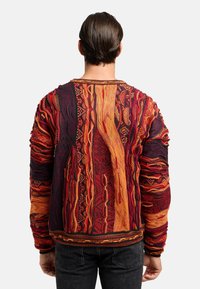 Strickpullover in Rot-, Orange- und Schwarztönen mit strukturierten Mustern und bequemer Passform. Mit gerippten Bündchen und Saum. Rückansicht dargestellt.
