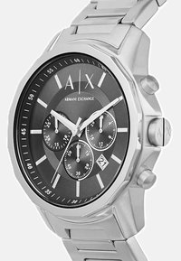 Hõbedane roostevabast terasest kell musta dialiga, kronograafi funktsioonidega, valgete markerite ja kuupäeva näiduga kell 6.