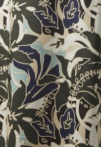 Tygt mönster med mörkgröna, beige och blå blommönster, med djärva svarta konturer och intrikata bladdetaljer. Strukturerad utseende.