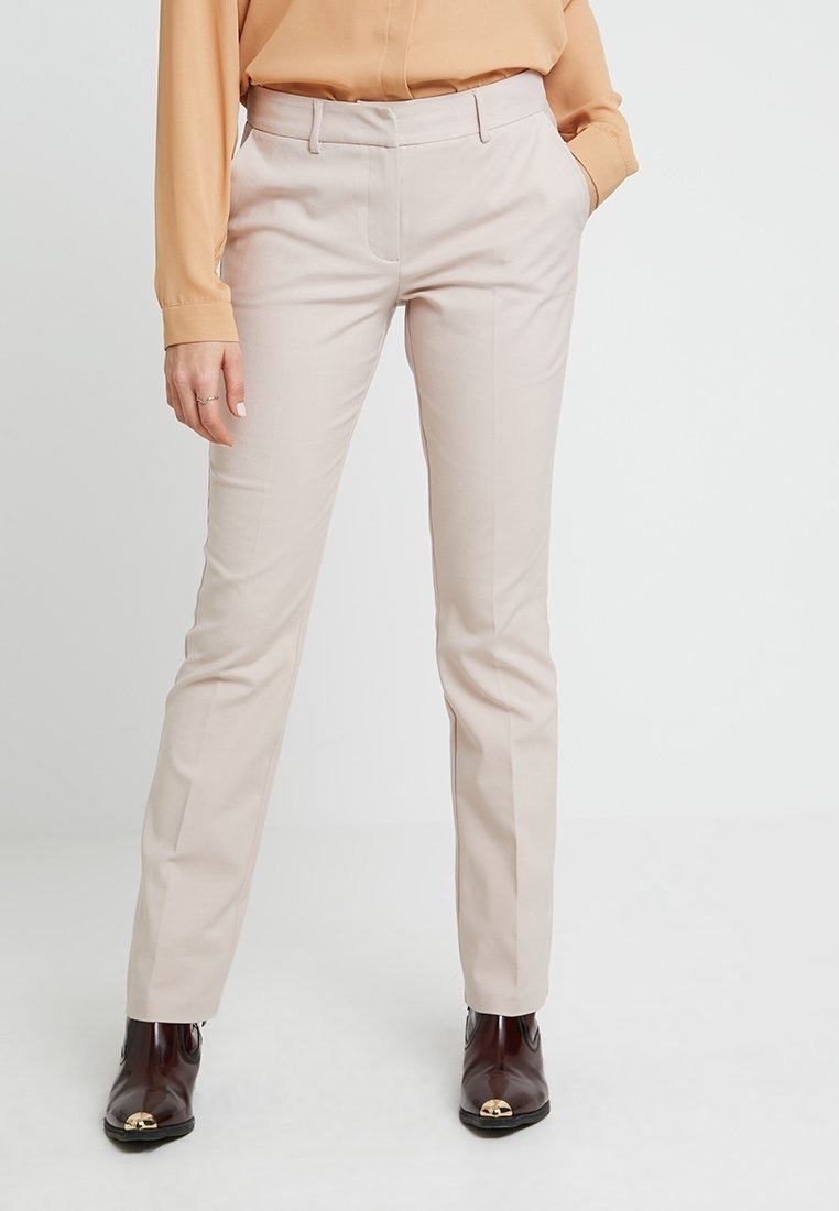 Pantalon beige clair sur mesure avec une coupe droite élégante. Présente un devant plat, des poches latérales et des détails de couture subtils.