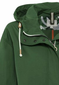 Veste à capuche verte avec cordon blanc, boutons-pression noirs, fermeture éclair et doublure intérieure à motif visible près du col.