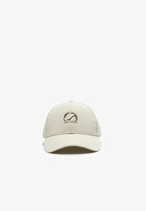Cappellino da baseball beige con visiera curva, caratterizzato da un logo e un simbolo metallici "No Name" al centro frontale.