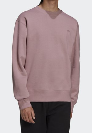Felpa rosa chiaro realizzata in materiale morbido, con scollo rotondo e polsini a coste. Design minimalista con un piccolo logo sul petto.