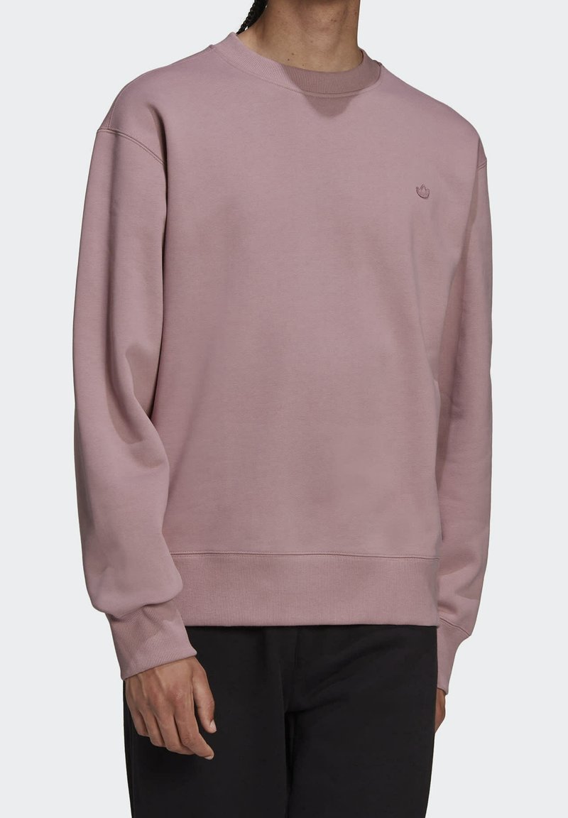 Felpa rosa chiaro realizzata in materiale morbido, con scollo rotondo e polsini a coste. Design minimalista con un piccolo logo sul petto.